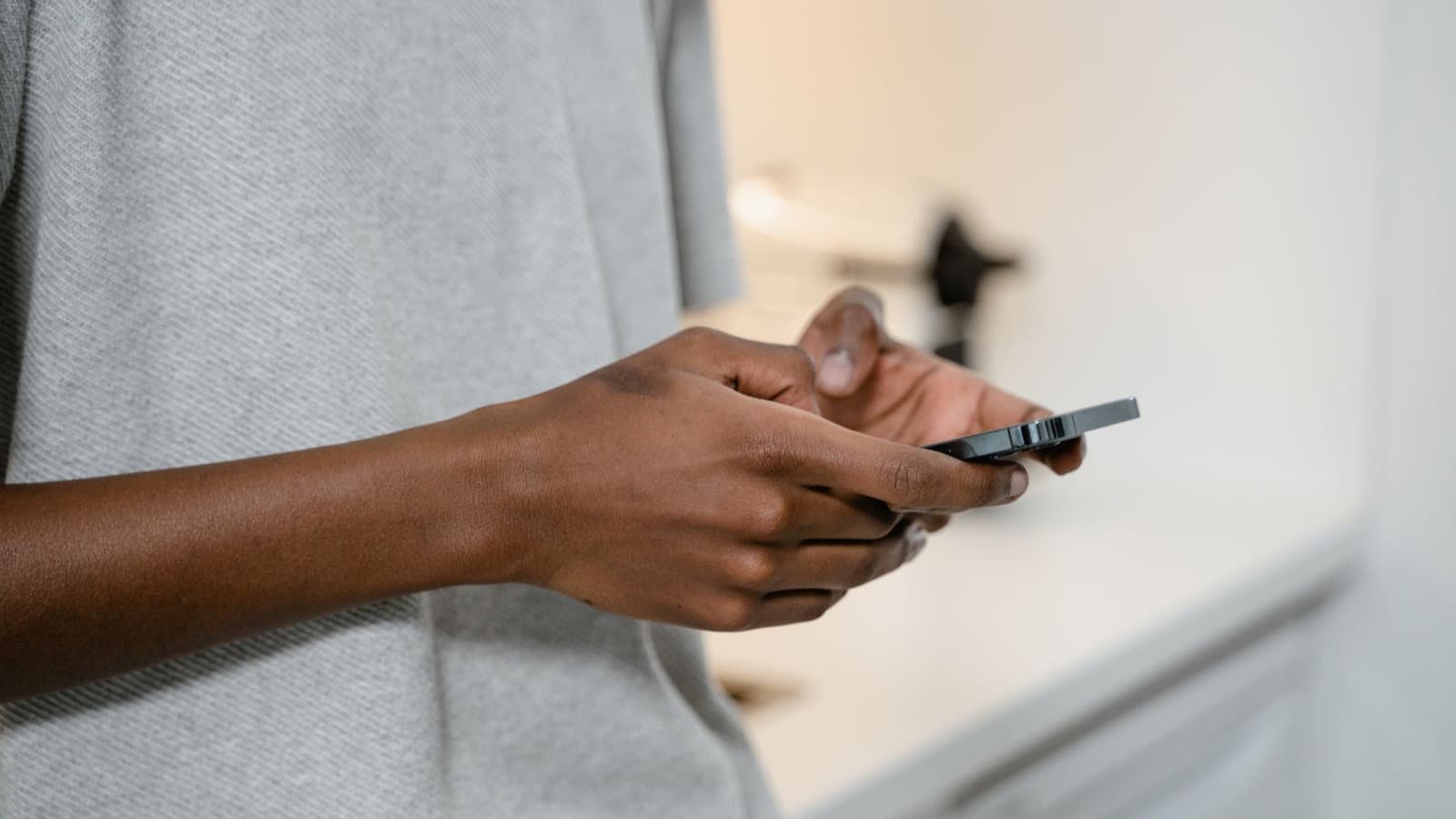 Mãos segurando um smartphone, no gesto de dar o primeiro passo