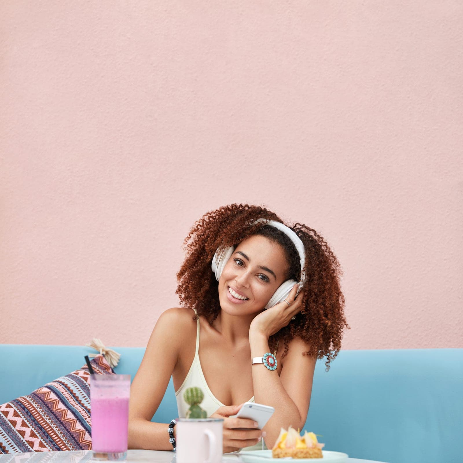 Mulher sorrindo, ouvindo música em um momento tranquilo do seu dia